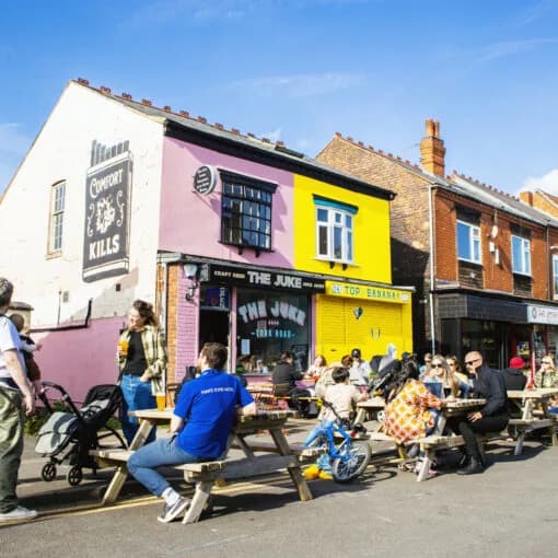 People enjoying outdoor tables on York Road in Kings Heath