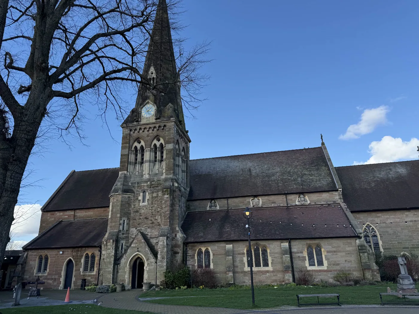 All Saints Church and clock tower beneath a clear blue sky