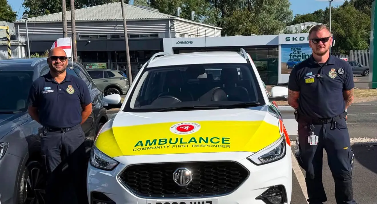 Two emergency responders with an Arrive Alive ambulance vehicle