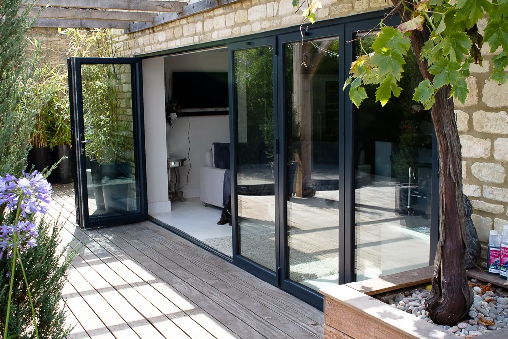 Black aluminium bifold doors opening onto a patio