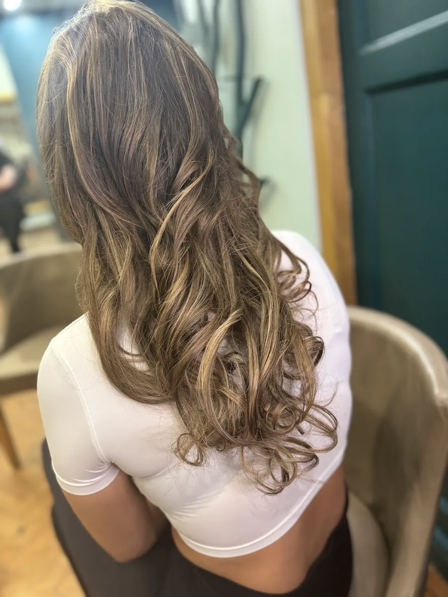 Long curled hairstyle finished at Coustis Hair and Beauty