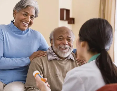 A home care worker discussing medication with an older couple
