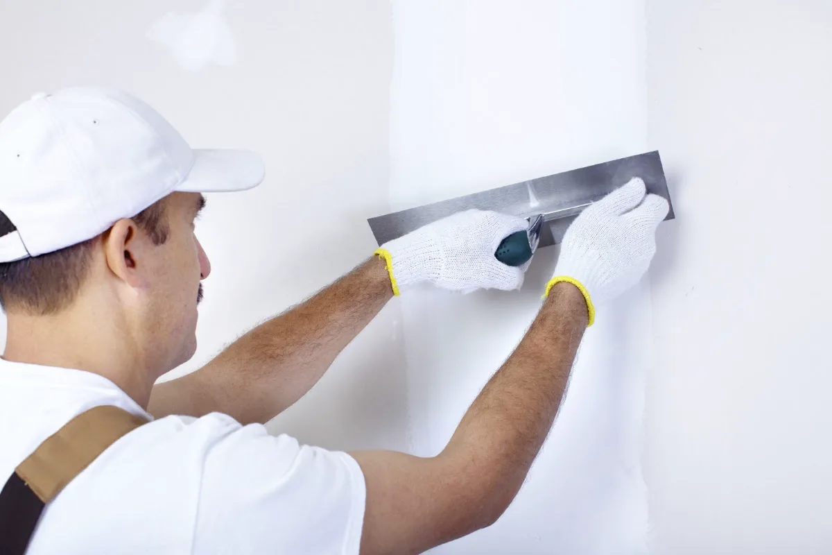 A plasterer smoothing an interior wall