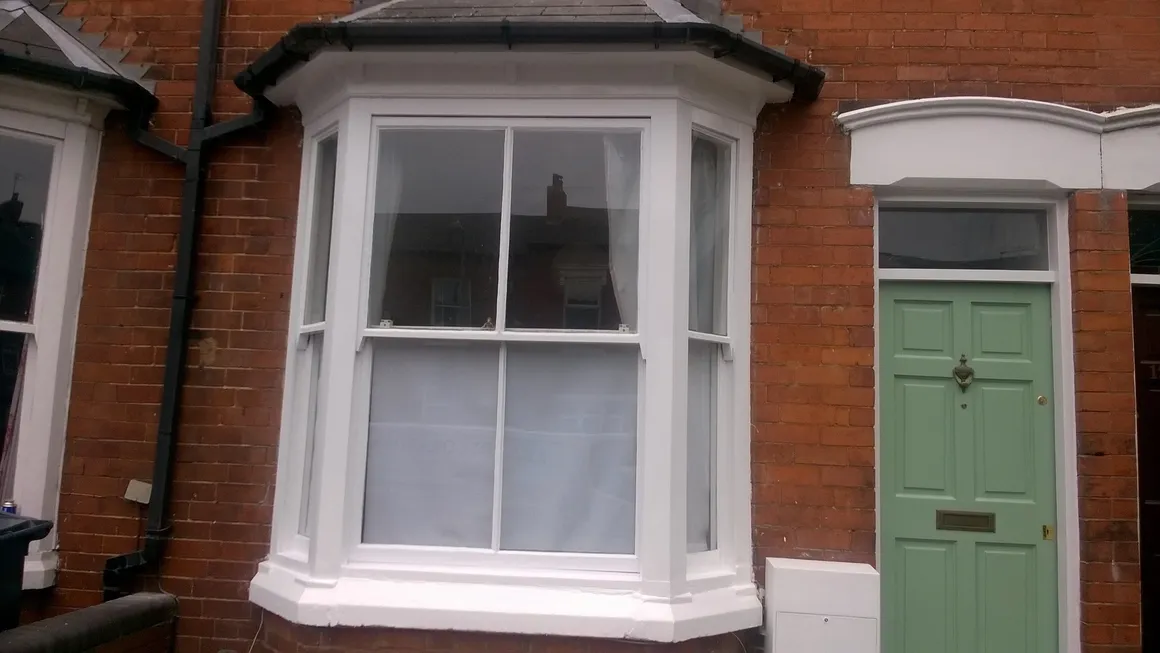 Freshly painted bay window and front door on a terraced house in Moseley