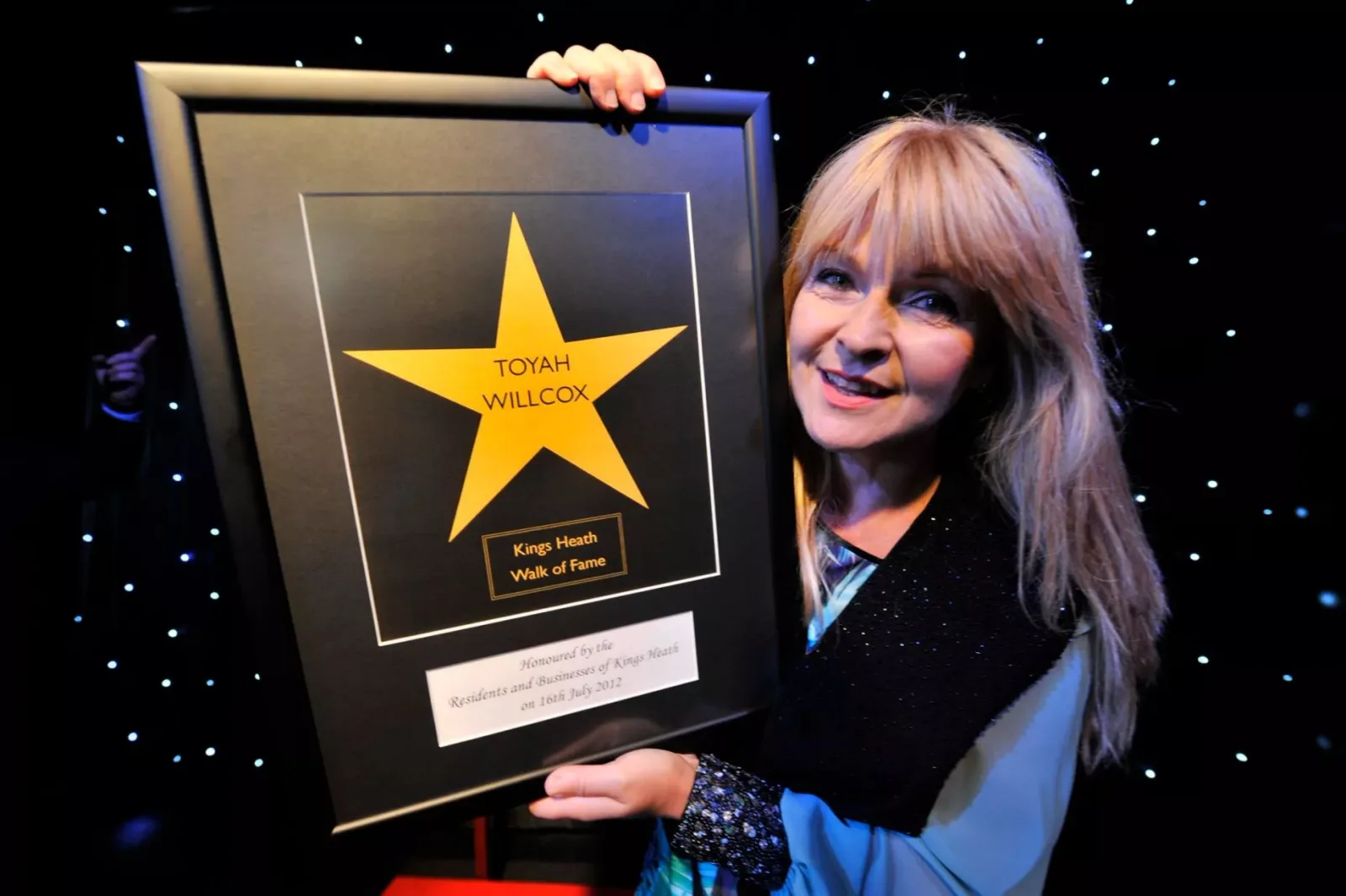 Toyah Willcox holding her framed Kings Heath Walk of Fame star
