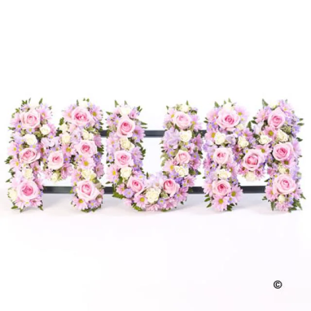 Pink floral tribute spelling love by Whoops a Daisy