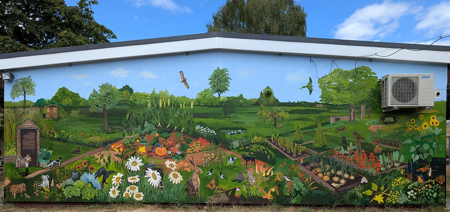 Pamina Stewart’s mural across the Moor Green clubhouse, filled with allotment plots, flowers, birds and wildlife beneath a blue sky.